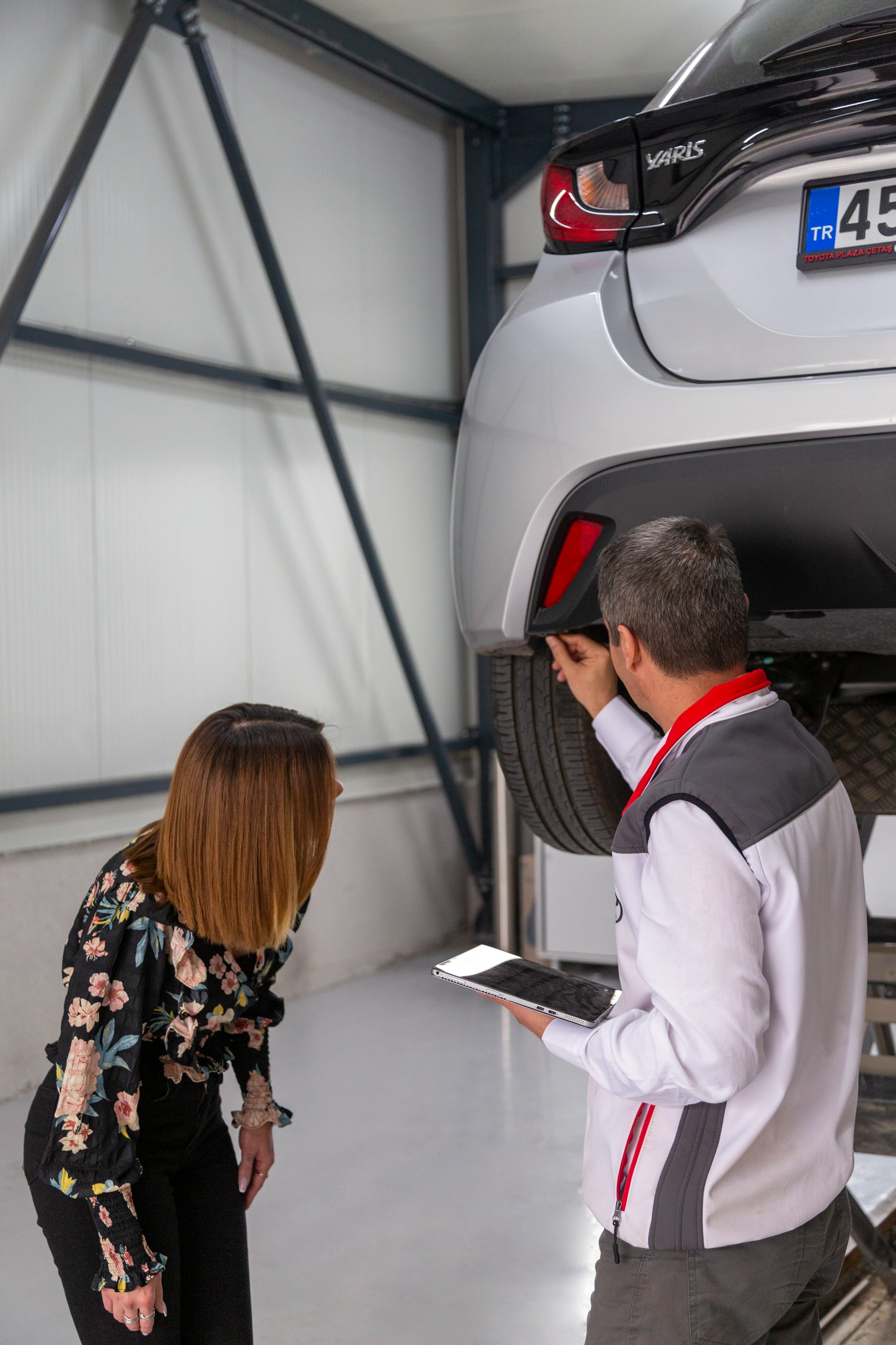 a car service worker showing a car owner the car services done on her car